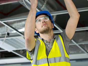 Electrician working on a ceiling electrical system 